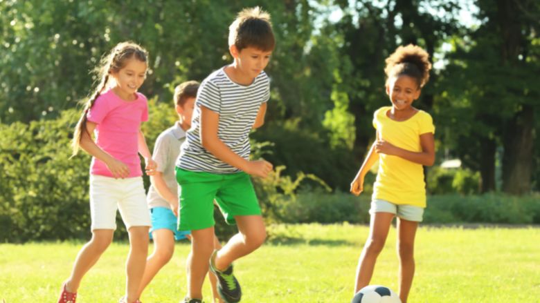 サッカーボールを追いかける10才くらいの子どもたち